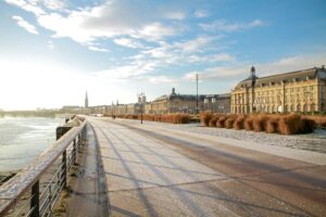 Quais de Bordeaux en hiver avec une légère couverture de neige et une vue sur la Place de la Bourse.